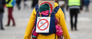 Eine Teilnehmerin einer Protestkundgebung der Initiative „Querdenken“ trägt auf dem Cannstatter Wasen ein Schild gegen Impfungen auf ihrem Rücken. 