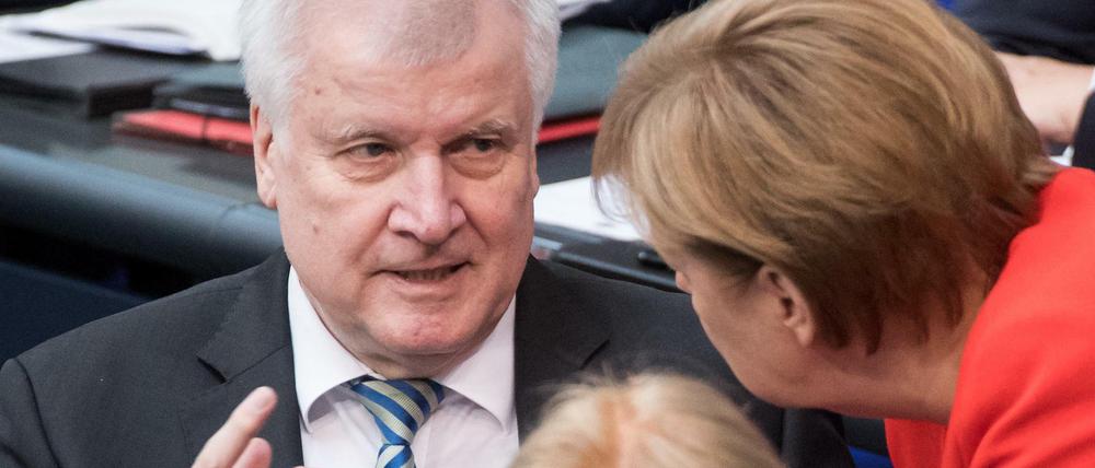 Horst Seehofer (CSU), Bundesminister für Inneres und Bundeskanzlerin Angela Merkel (CDU) bei der Plenarsitzung im Deutschen Bundestag. 