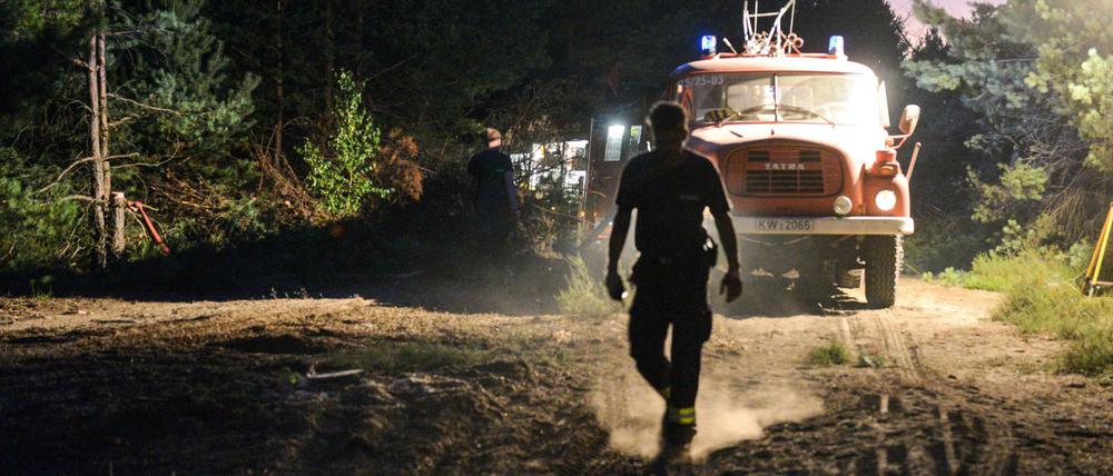 Feuerwehrleute löschen mit schwerer Technik die Glutnester auf dem ehemaligen Truppenübungsplatz Lieberoser Heide in Südbrandenburg.