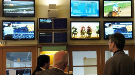 Männer, die auf Monitore starren: In Wettbüros herrscht eine ganz eigene Stimmung. Und Luftbelastung. 