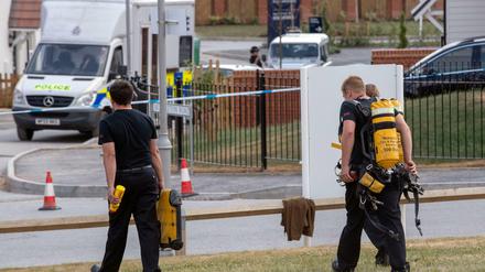 Feuerwehrleute tragen ihre Ausrüstung zum Tatort in der Muggleton Road in Amesbury, wo Antiterroroffiziere ermitteln. 
