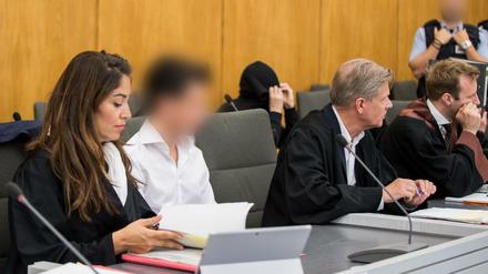 Die Angeklagten (2.v.l, 3.v.l) sitzen im Gerichtssaal neben ihren Anwälten Gönül Üstebay (l) und Hans Reinhardt (4.v.l). 
