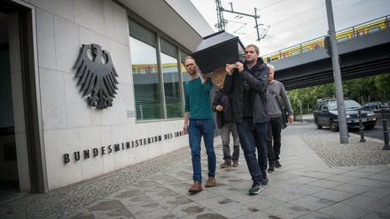 Menschen gedenken vor dem Bundesinnenministerium mit einem symbolischen Sarg Jamal Nasser M., der sich nach seiner Abschiebung in Kabul das Leben genommen hat. 