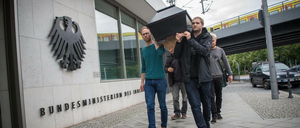 Menschen gedenken vor dem Bundesinnenministerium mit einem symbolischen Sarg Jamal Nasser M., der sich nach seiner Abschiebung in Kabul das Leben genommen hat. 