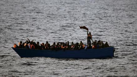 Flüchtlinge aus Afrika rufen auf dem Mittelmeer in einem Boot um Hilfe (Archivbild).