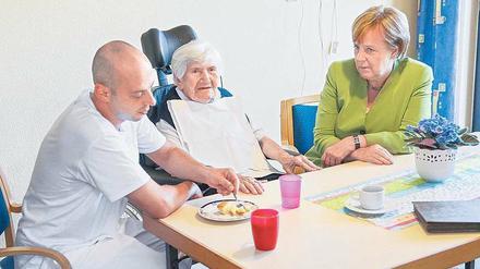 Versprechen gehalten. Die Kanzlerin mit Pfleger Cebi im Heim. 