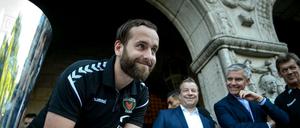 Hat gut lachen: Silvio Heinevetter (M.), Torhüter bei den Füchsen Berlin, beim Eintragen ins Goldene Buch des Bezirks Reinickendorf nach dem Gewinn des EHF-Pokals.