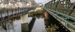 09.11.2021, Hessen, Weilburg: Der "Eiserne Steg" (l), die neu errichtete Rad- und Gehwegbrücke über die Lahn, liegt direkt neben dem Eisenbahnsteg. Die Brücke hat es ins Schwarzbuch des Steuerzahlerbundes geschafft. Weil die Stadt Weilburg (Kreis Limburg-Weilburg) eine neue Rad- und Gehwegbrücke über die Lahn gebaut habe, statt gemeinsam mit der Deutschen Bahn den jahrzehntelang genutzten Eisenbahnsteg instand zu setzen, stiegen die Ausgaben stark. Für Gesamtkosten von 2,2 Millionen Euro sei eine deutlich komfortablere Lösung als bei einer Sanierung des Stegs realisiert worden. Foto: Nadine Weigel/dpa +++ dpa-Bildfunk +++