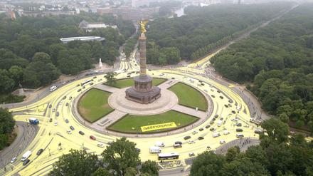 Sonne statt Kohle: Aktivisten der Umweltschutz-Organisation Greenpeace tragen rund um den Großen Stern an der Siegessäule ökologisch abbaubare und -waschbare Farbe auf.