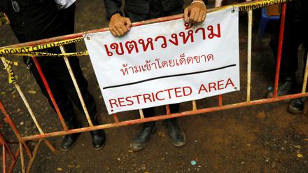 Polizisten stehen vor dem Tham Luang Höhlenkomplex Wache.