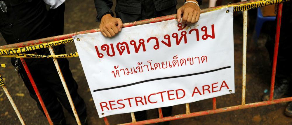 Polizisten stehen vor dem Tham Luang Höhlenkomplex Wache.