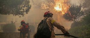 Feuerwehrleute bekämpfen einen Waldbrand in der Nähe von Athen.