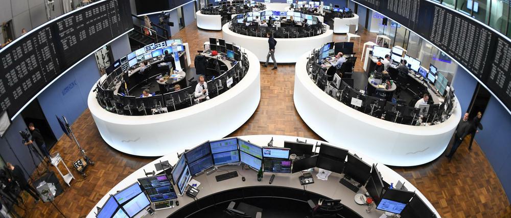 Börsenhändler sitzen im Handelssaal der Frankfurter Wertpapierbörse an ihren Arbeitsplätzen.