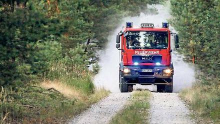 Freiwillige Feuerwehr im Einsatz auf einem Waldweg.