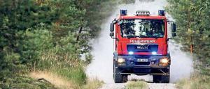 Freiwillige Feuerwehr im Einsatz auf einem Waldweg.