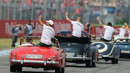 Lewis Hamilton (links) mit dem Team von Mercedes auf Werberundfahrt.