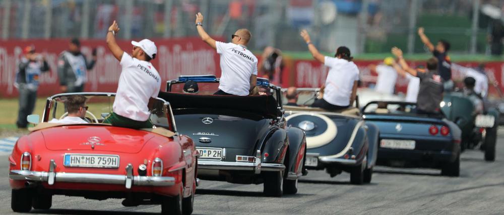 Lewis Hamilton (links) mit dem Team von Mercedes auf Werberundfahrt.