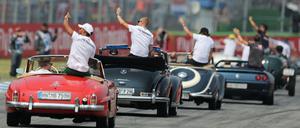 Lewis Hamilton (links) mit dem Team von Mercedes auf Werberundfahrt.
