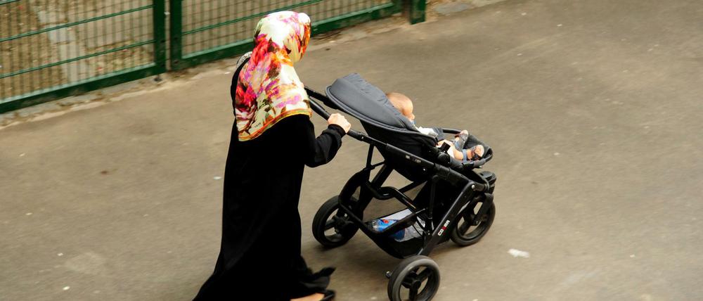 Eine Frau mit Kinderwagen in der Nähe des Kottbusser Tors in Kreuzberg.