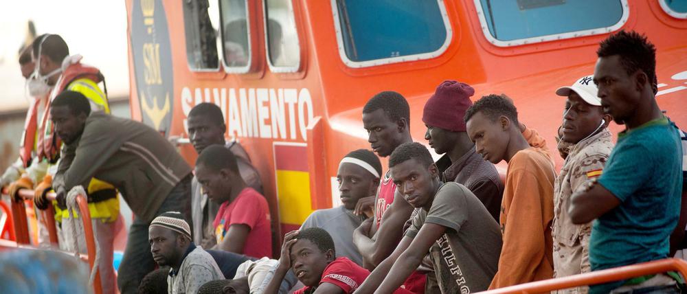 Migranten kommen auf einem Rettungsboot im Hafen von Malaga an.