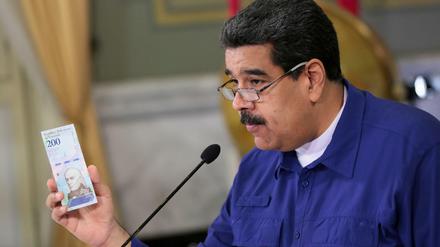 Venezuelas Präsident Nicolas Maduro präsentiert eine der neuen Banknoten.