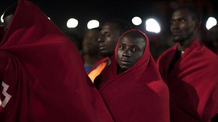 In Decken gehüllte afrikanische Flüchtlinge warten in Motril darauf, vom Roten Kreuz registriert zu werden.