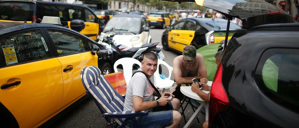 Taxifahrer blockieren mit Tischen und Stühlen die Gran Via in Barcelona, während sie an einem Streik teilnehmen. Aus Ärger über zu viele Lizenzvergaben an Konkurrenz-Unternehmen wie Uber und Cabify sind die Taxifahrer in einen unbefristeten Streik getreten.