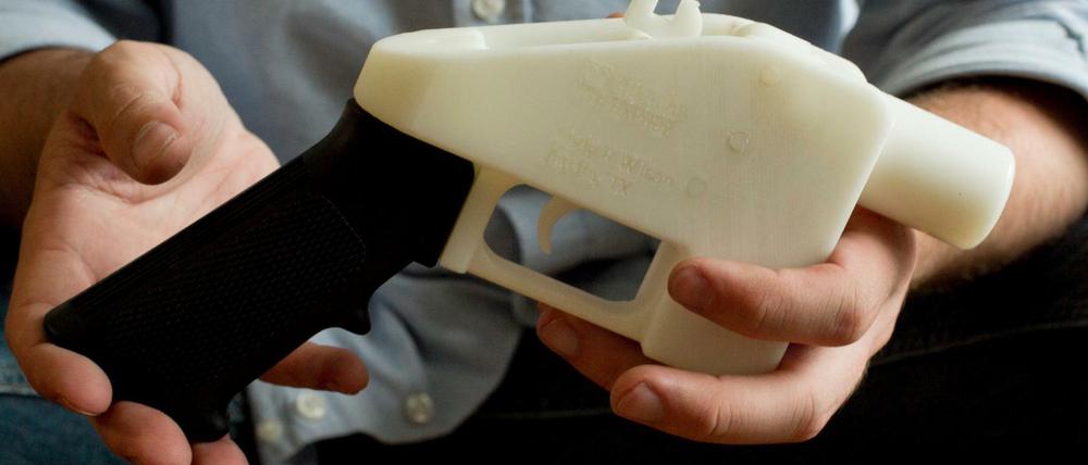 Eine Person hält eine Plastik-Pistole, die komplett im 3D-Drucker hergestellt wurde.