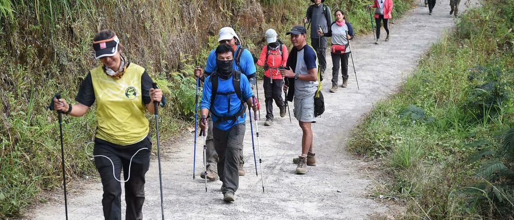 Indonesische und ausländische Wanderer im Gebiet Rinjani, beim Abstieg vom Vulkan.