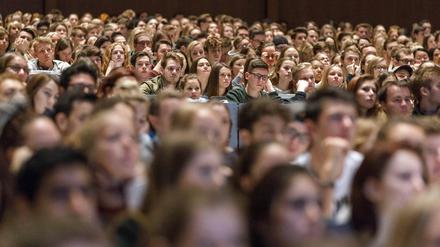 Studierende sitzen in einem vollbesetzten Hörsaal.