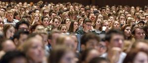 Studierende sitzen in einem vollbesetzten Hörsaal.