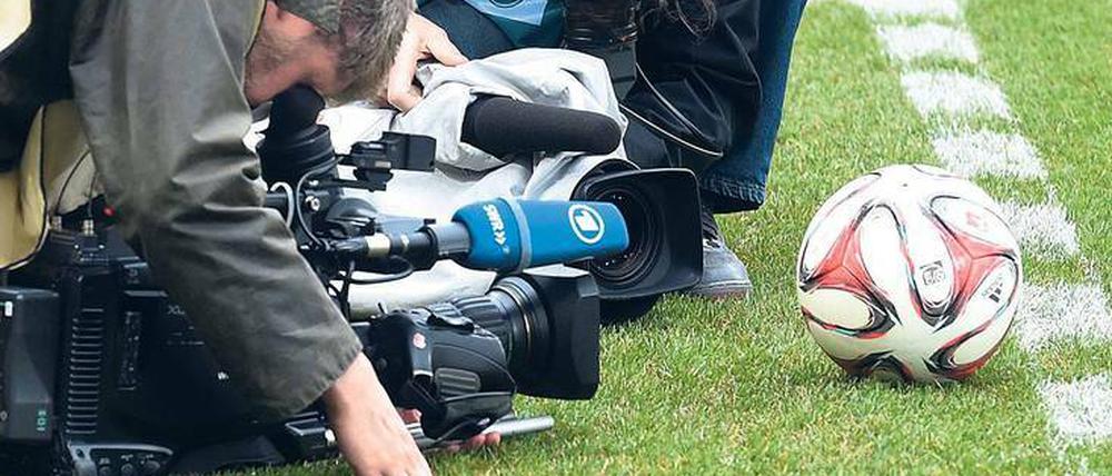 Begierde des Objektivs. Fernsehen und Fußball sind fest miteinander verbunden. Der Fan ist Dritter im Bunde, vorausgesetzt, er bezahlt. 