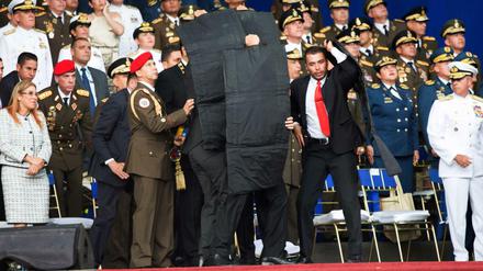 Sicherheitsbeamte stellen sich schützend vor den venezolanischen Präsidenten Nicolas Maduro