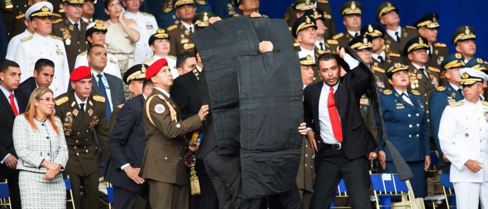 Sicherheitsbeamte stellen sich schützend vor den venezolanischen Präsidenten Nicolas Maduro