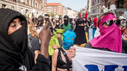 01.08.2018, Dänemark, Kopenhagen: Demonstranten haben bei einem Protest gegen das Verbot von Burkas und Nikabs teilweise ihr Gesicht verhüllt. 