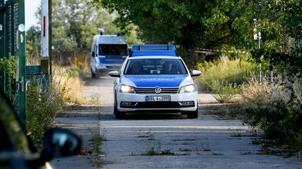 Fahrzeuge der Kriminalpolizei verlassen den Einsatzort.