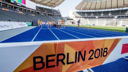 Helfer stellen bei den Vorbereitungen im Olympiastadion die Hürden auf der Laufbahn auf. 