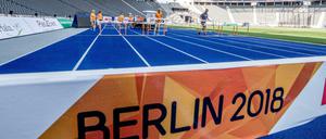 Helfer stellen bei den Vorbereitungen im Olympiastadion die Hürden auf der Laufbahn auf. 