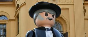 Vor der Kulturkirche in Neuruppin steht eine riesige Playmobilfigur Fontanes.