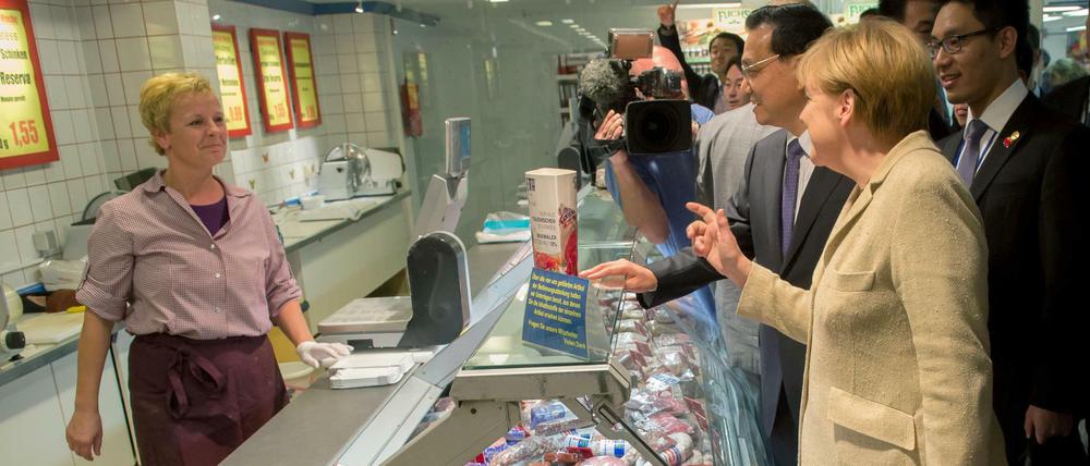 Bundeskanzlerin Angela Merkel kauft ein. An ihrer Seite: der chinesische Ministerpräsident Li Keqiang, geschehen am 10. Oktober 2014 im Verbrauchermarkt an der Mohrenstraße.