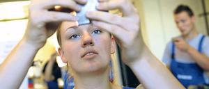 Eine dual Studierende prüft in ihrem Ausbildungsbetrieb ein Werkstück.