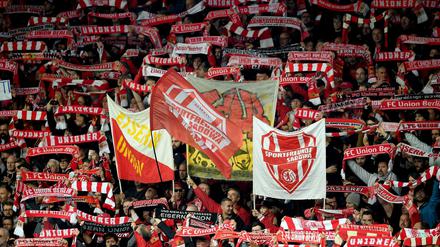 Fans von Union Berlin mit Schals und Fahnen im Stadion.