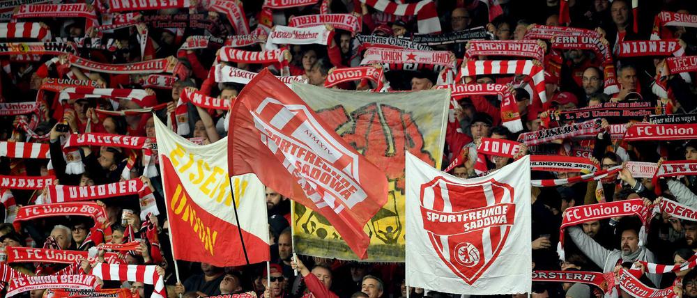 Fans von Union Berlin mit Schals und Fahnen im Stadion.