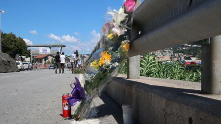 Ein Blumenstrauss steht in einiger Entfernung von der eingestürzten Brücke.