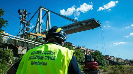 Ein Arbeiter inspiziert das Gebiet um die eingestürzte Autobahnbrücke.