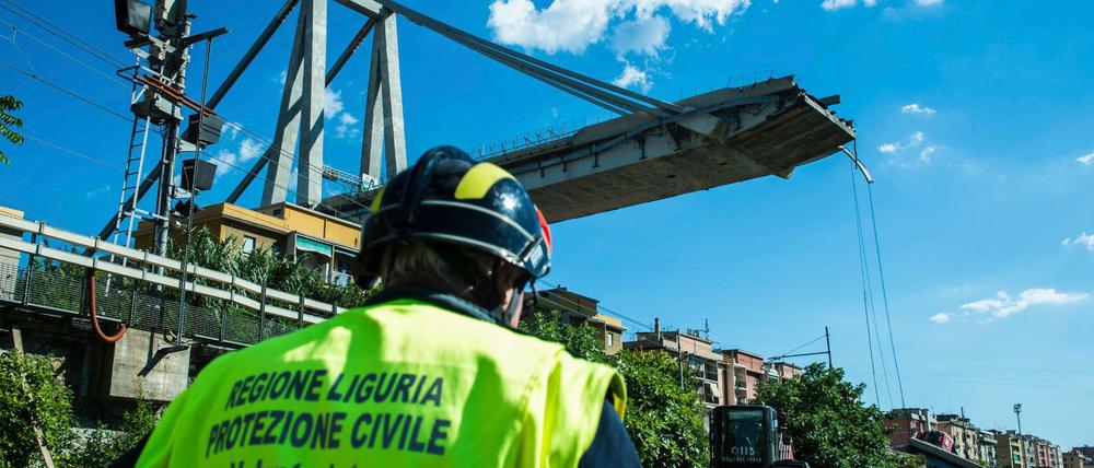 Ein Arbeiter inspiziert das Gebiet um die eingestürzte Autobahnbrücke.