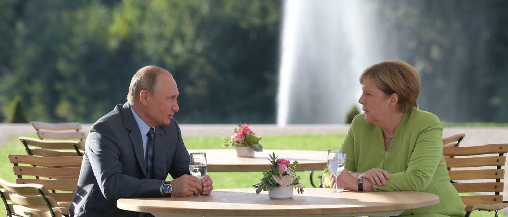 Der russische Präsident Wladimir Putin und Bundeskanzlerin Angela Merkel im Garten von Schloss Meseberg. 