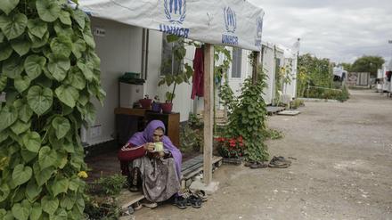 Eine Frau trinkt Tee vor ihrer Unterkunft im Flüchtlingslager Schisto bei Athen.