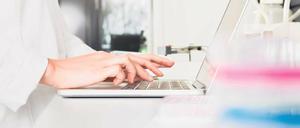 Eine Wissenschaftlerin gibt im Labor Daten in einen Laptop ein.