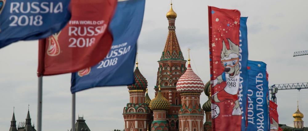 Willkommensflaggen mit dem Logo der Fußball WM 2018 wehen vor der Basilius-Kathedrale in Moskau.